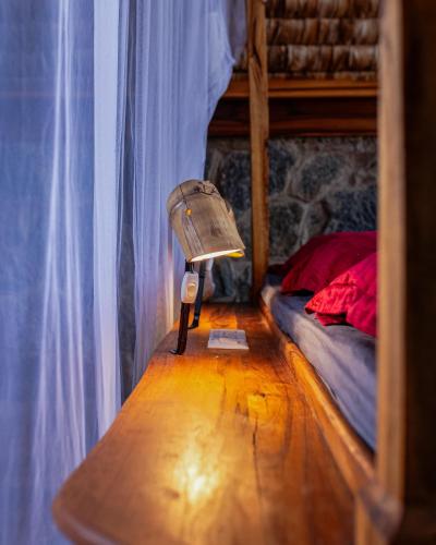 a lamp on a wooden floor in a room with a bunk bed at Shamba Pori Lodge in Idulo
