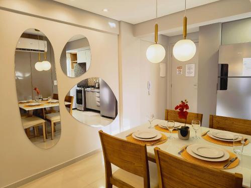 a dining room with a table and chairs and a mirror at Rio Park Avenue, Espaço Familia - by TRH Home Stay in Recife