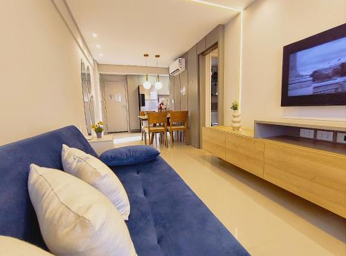 a living room with a blue couch and a television at Rio Park Avenue, Espaço Familia - by TRH Home Stay in Recife