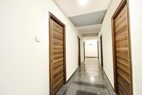 a corridor with wooden doors in a room at FabHotel The Botanica- Nr Hmwssb Kondapur section office-Masjid Banda, Kondapur in Kondapur
