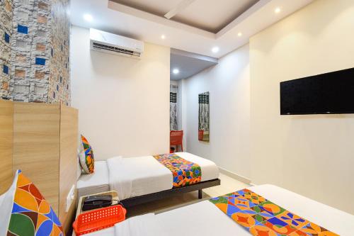 a bedroom with a bed and a flat screen tv at FabHotel The Botanica- Nr Hmwssb Kondapur section office-Masjid Banda, Kondapur in Kondapur