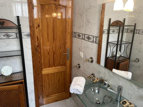 a bathroom with a sink and a wooden door at Casa Encanto de Nerja by At Home costa del sol in Nerja