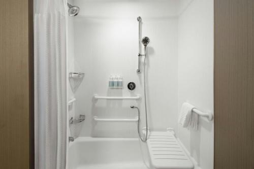 a white bathroom with a shower and a tub at Courtyard by Marriott Fayetteville Fort Liberty - Spring Lake in Spring Lake