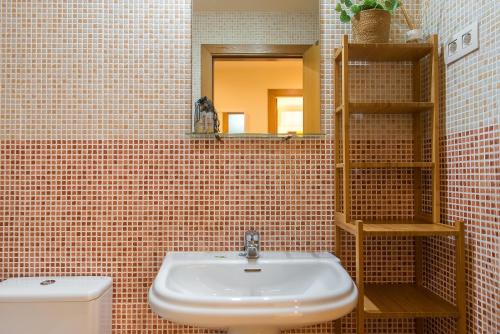 Un baño con lavabo, inodoro y espejo. en WELCS APARTAMENTO 209 PDA en Palafrugell, en Palafrugell