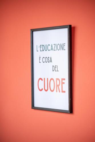 a framed sign on an orange wall at Ostello Stella Del Mare in Varazze