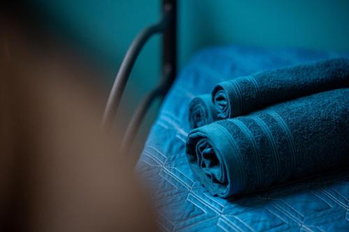 two rolls of blue towels sitting on a bed at Ostello Stella Del Mare in Varazze