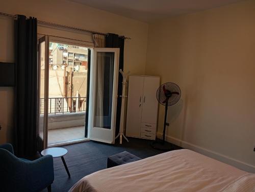 a bedroom with a bed and a door to a balcony at A bright room in the heart of Cairo in Cairo