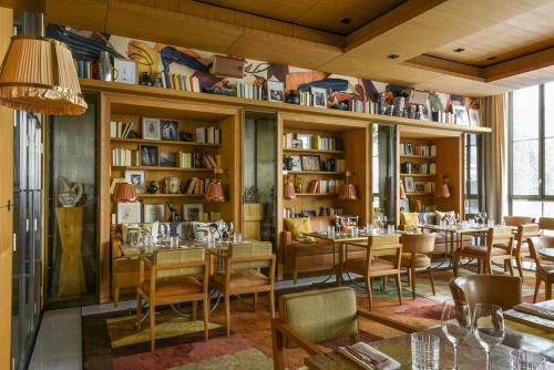 a restaurant with tables and chairs and bookshelves at Brach Paris - Evok Collection in Paris