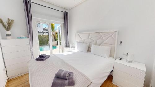 a white bedroom with a large bed and a window at Casa NY - A Murcia Holiday Rentals Property in Roldán