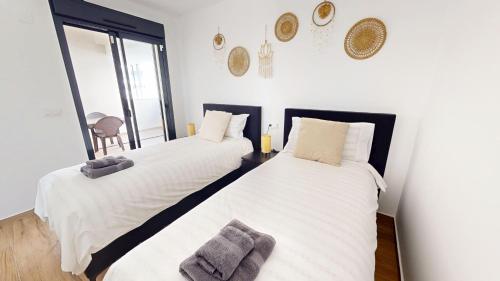2 Einzelbetten in einem Zimmer mit weißen Wänden in der Unterkunft Casa Velapi - A Murcia Holiday Rentals Property in Roda
