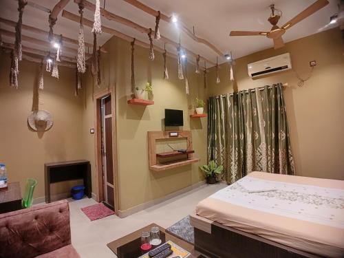 a bedroom with a bed and a couch and a tv at The Sea Horse in Mandarmoni