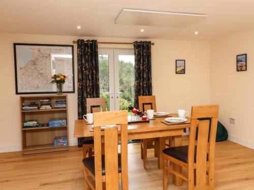 a dining room with a wooden table and chairs at Hideaway in Great Torrington