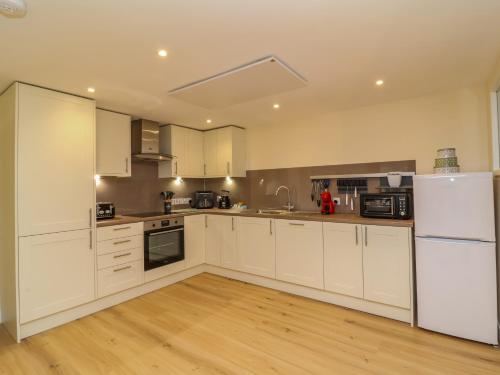 a large kitchen with white cabinets and appliances at Hideaway in Great Torrington