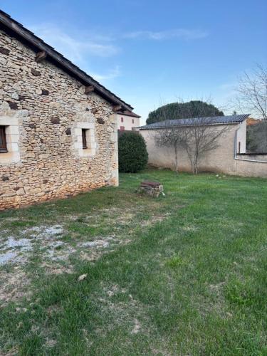 an empty yard next to a brick building at Gîte de Raynal in Les Junies