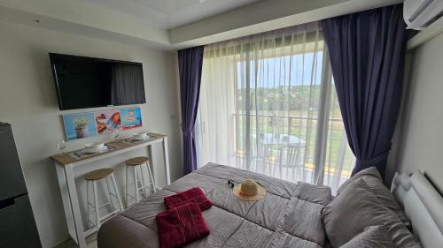 een slaapkamer met een bed en een groot raam bij Sunset view studio at 777 Beach Condo in Ban Mai Salae