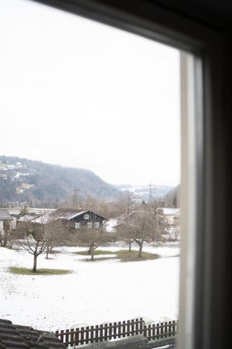 a view of a snow covered field from a window at homy MontaVista - 300m zur Golmerbahn in Vandans