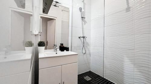 a white bathroom with a shower and a sink at Le Saphir Central - Cosy - Gare in Mâcon