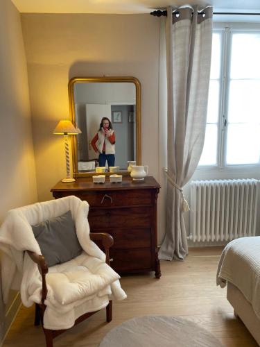 a woman taking a picture of a mirror in a bedroom at Belle Fontaine in Bourges