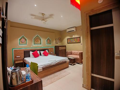 a bedroom with a bed with red pillows and a couch at The Sea Horse in Mandarmoni