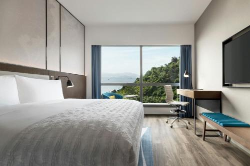 a hotel room with a bed and a large window at Le Méridien Hong Kong, Cyberport in Hong Kong