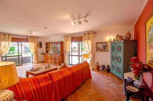 un soggiorno con divano rosso in una camera di Elegant Villa in Loulé with Private Pool a Loulé