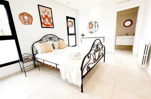 a white bedroom with a black bed in a room at Residence Jannet 2 Luxury Seaside 3bds in Hammamet Nord