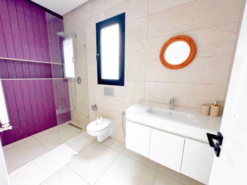 a bathroom with a white toilet and a purple door at Residence Jannet 2 Luxury Seaside 3bds in Hammamet Nord