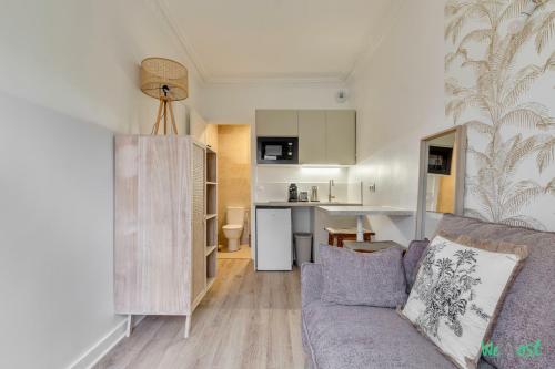 un salon avec un canapé et une cuisine dans l'établissement Vallée 2 - LB - Bright flat just outside Paris, à Malakoff