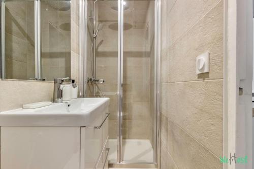 une salle de bain avec un lavabo et une douche dans l'établissement Vallée 2 - LB - Bright flat just outside Paris, à Malakoff