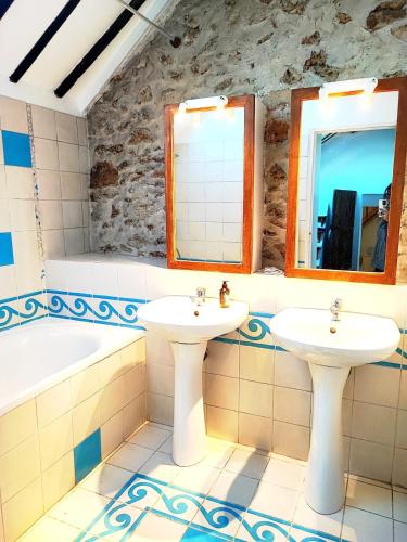 une salle de bain avec deux lavabos et une baignoire dans l'établissement maison chaleureuse avec jardin, à Savigny-sur-Orge