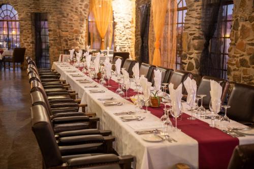 a long table in a room with white tables and chairs at Le Mirage Resort & Spa in Sesriem