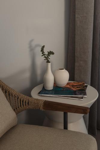 a table with a vase and a plant on it at Stamna Sifnos a member of Design Hotels in Sifnos