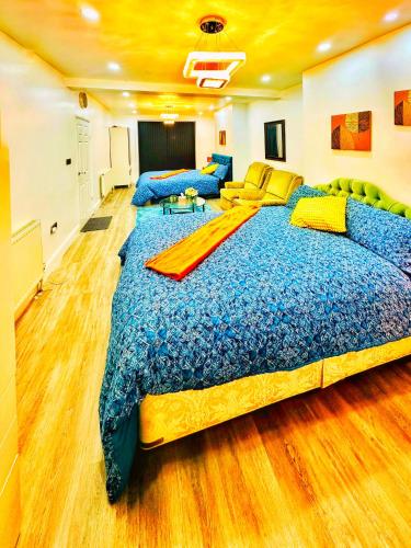 un grande letto con un piumone blu in una stanza di Smartstay a Wigston Magna