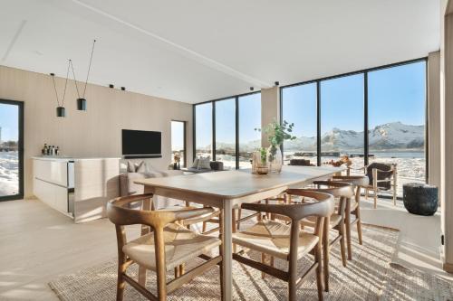 una cucina e una sala da pranzo con tavolo e sedie di Luxury Lodge in Lofoten - jacuzzi & sauna - LL20 a Lyngværet