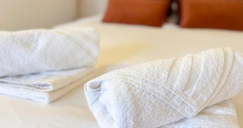 2 serviettes blanches assises au-dessus d'un lit dans l'établissement Parking Included - CLIM - Terrace - Hypercentre, à Avignon