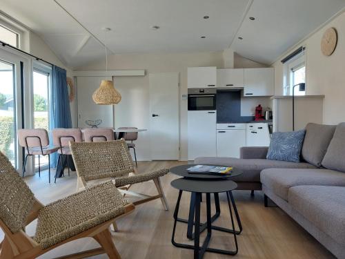 a living room with a couch and chairs and a table at Strandcamping Valkenisse in Biggekerke