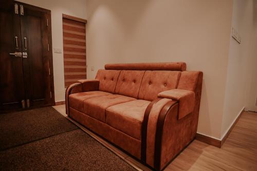 a brown couch sitting in a living room at Spice Legoon Munnar in Devikolam