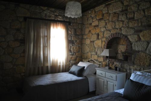 a bedroom with a bed and a window at Halkidiki Luxurious Stonehouses in Psakoudia
