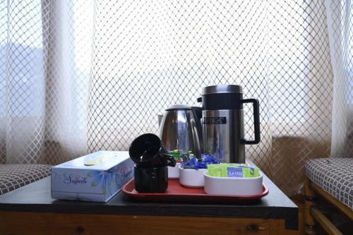 a coffee maker sitting on a table next to a box at The Castle in Kūfrī