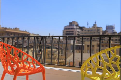 two chairs on a balcony with a view of a city at Hotel room in the heart of Cairo in Cairo