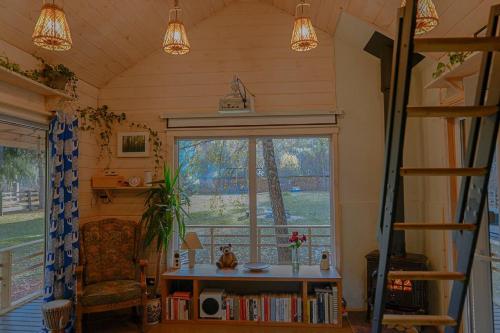 a room with a window and a table and a chair at Metai mikeA year in the forest in Paliepis