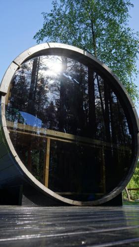 a circular building with the reflection of the sun in it at Metai mikeA year in the forest in Paliepis
