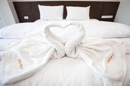 a bed with two white blankets forming a heart at Amatara Hotel in Pi Mai