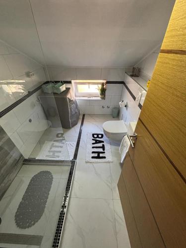 a small bathroom with a toilet and a door at Sobe i Apartman R Bileća in Bileća