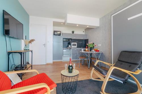 un salon avec un canapé et des chaises et une cuisine dans l'établissement L'horizon bleu - Vue mer - Berck-sur-mer, à Berck-sur-Mer