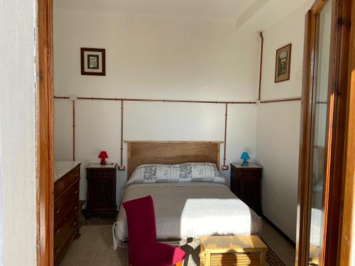 a bedroom with a bed and a red chair at Il Viandante in Recanati