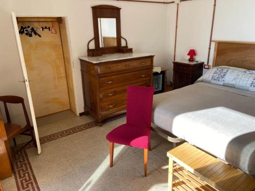 a bedroom with a bed and a chair and a dresser at Il Viandante in Recanati
