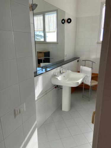a white bathroom with a sink and a mirror at Il Viandante in Recanati