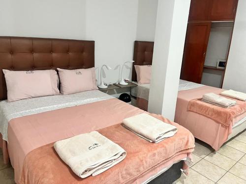 a bedroom with two beds with towels on them at DEL VALLE HOUSE II in Ica