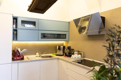 a kitchen with white cabinets and a sink at Ca' Baetti l'Antica Corte in Roncola